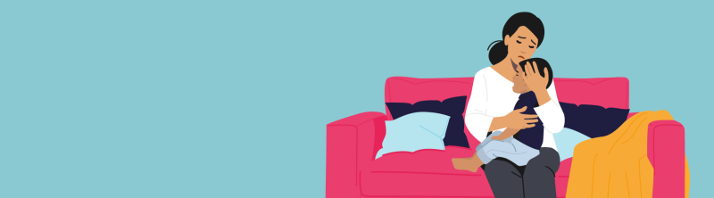 maman inquiète qui tient son bébé malade qui pleure assise sur un sofa